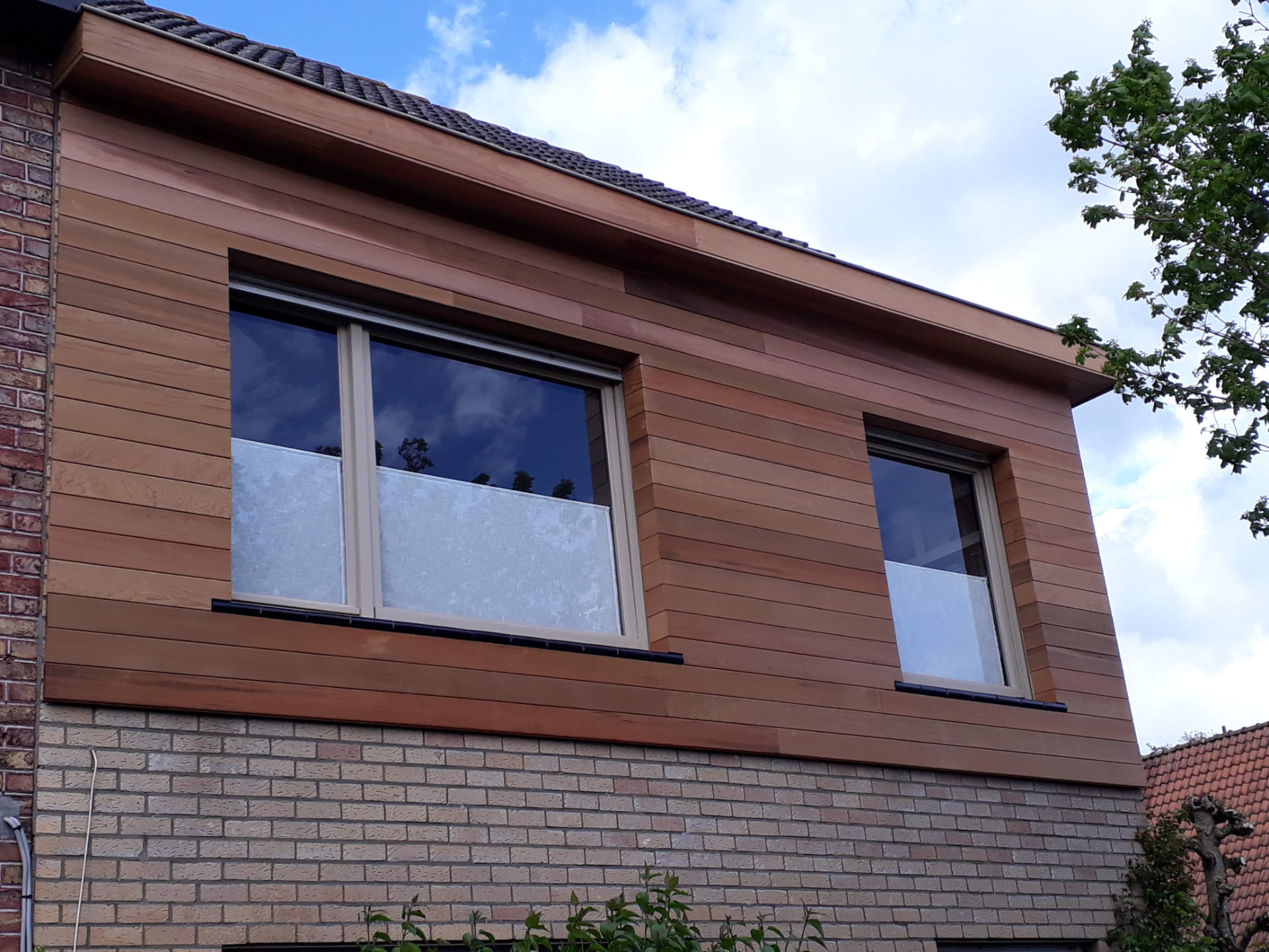 Houten gevelbekleding boven ramen