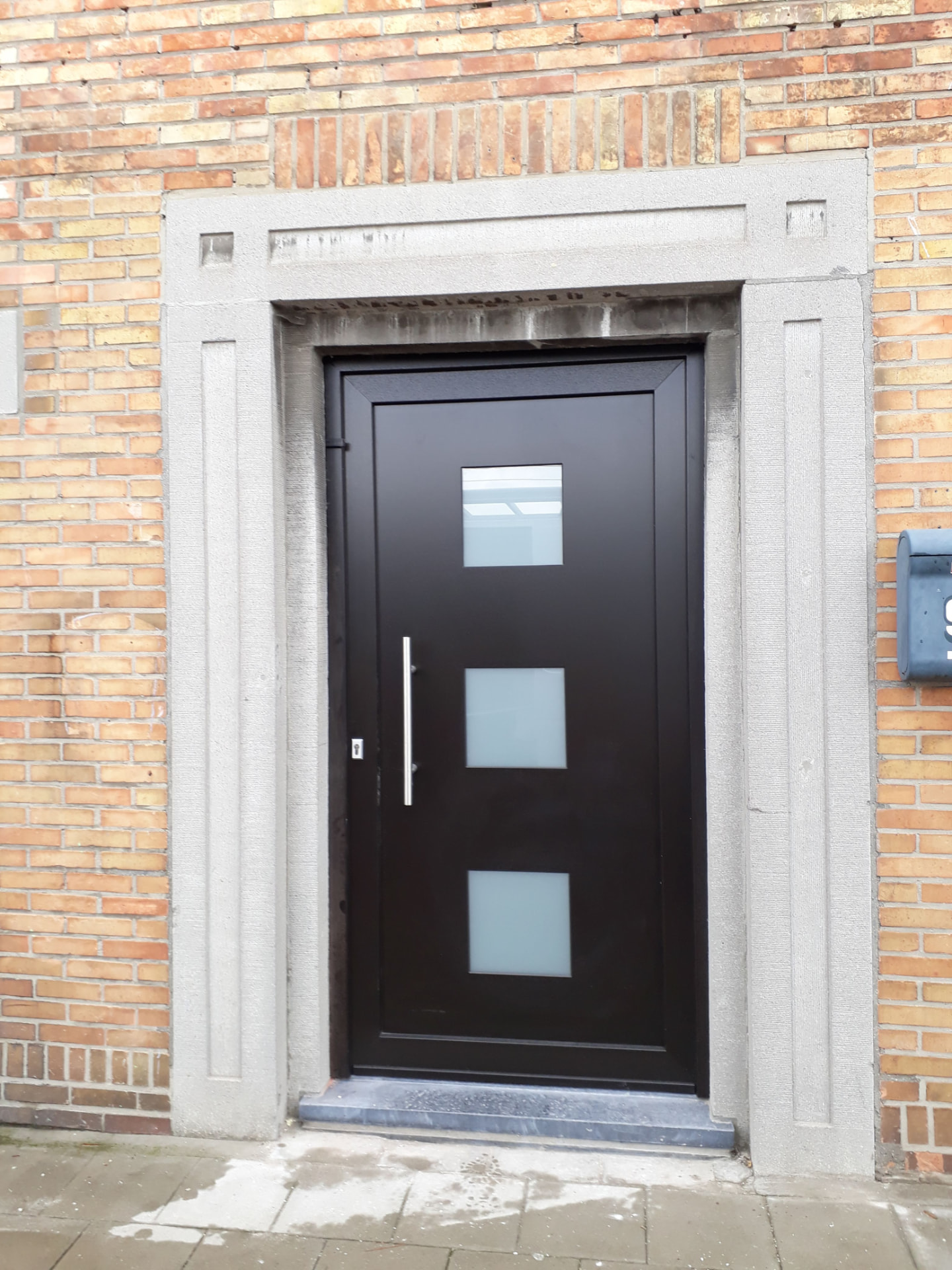 Zwarte voordeur met drie glaspanelen